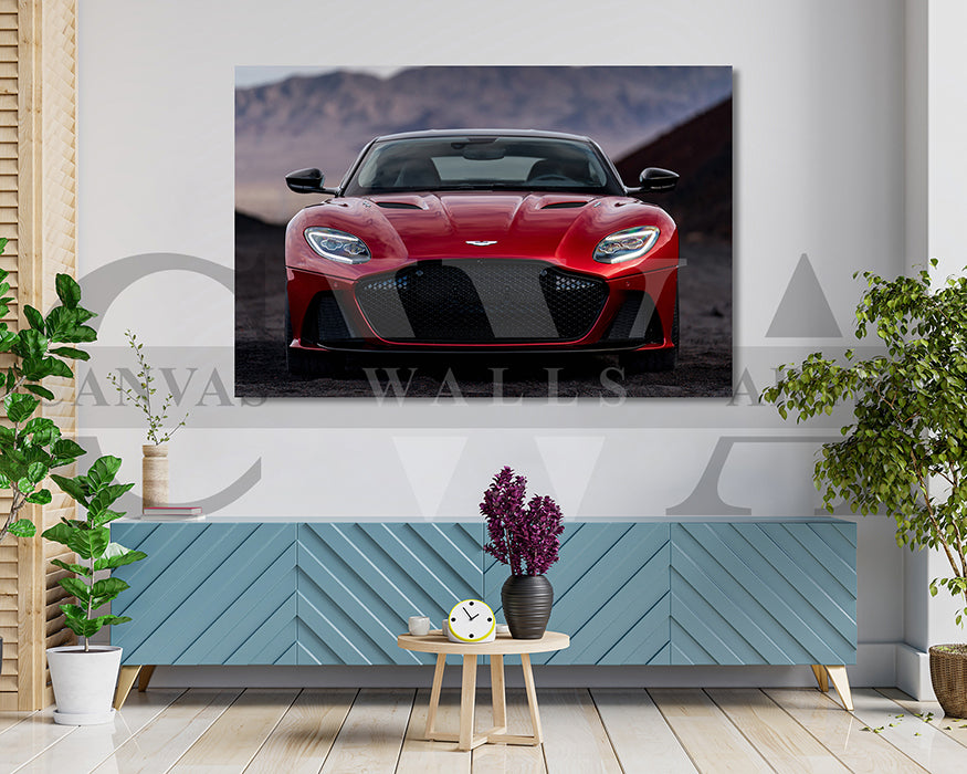 Red sports car on a wall display with a decorative table and plants below.